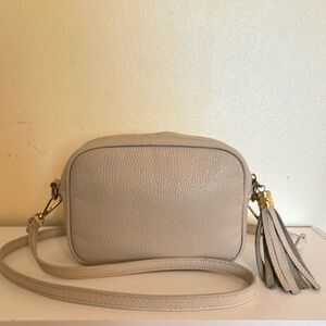 Small crossbody in pebble leather. Zip-top closure with a side tassel